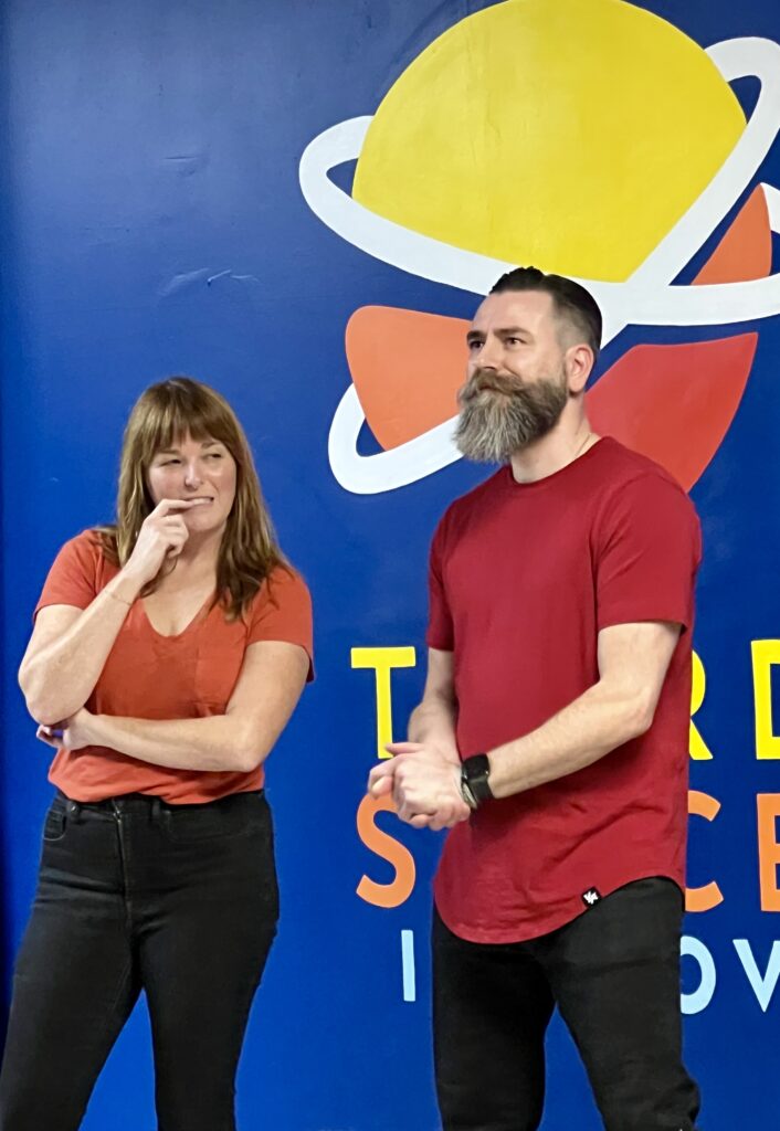 A female improv student and a male improv student on stage